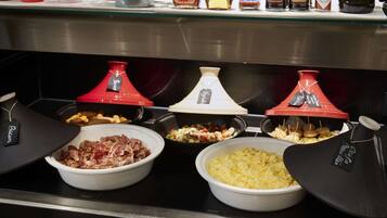 A buffet with various food items and condiments.