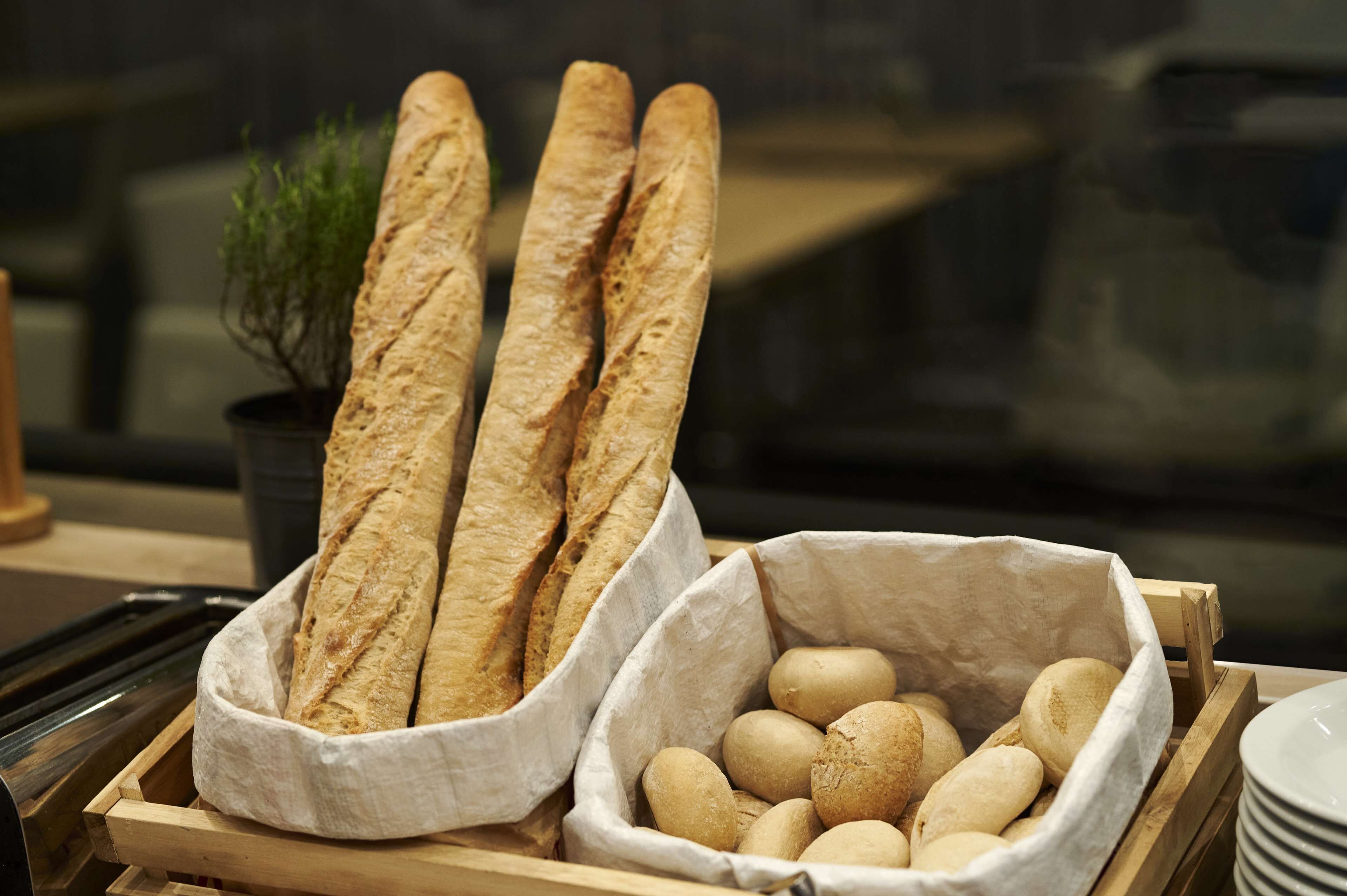 Un plateau avec deux paniers de pain et une plante en pot.
