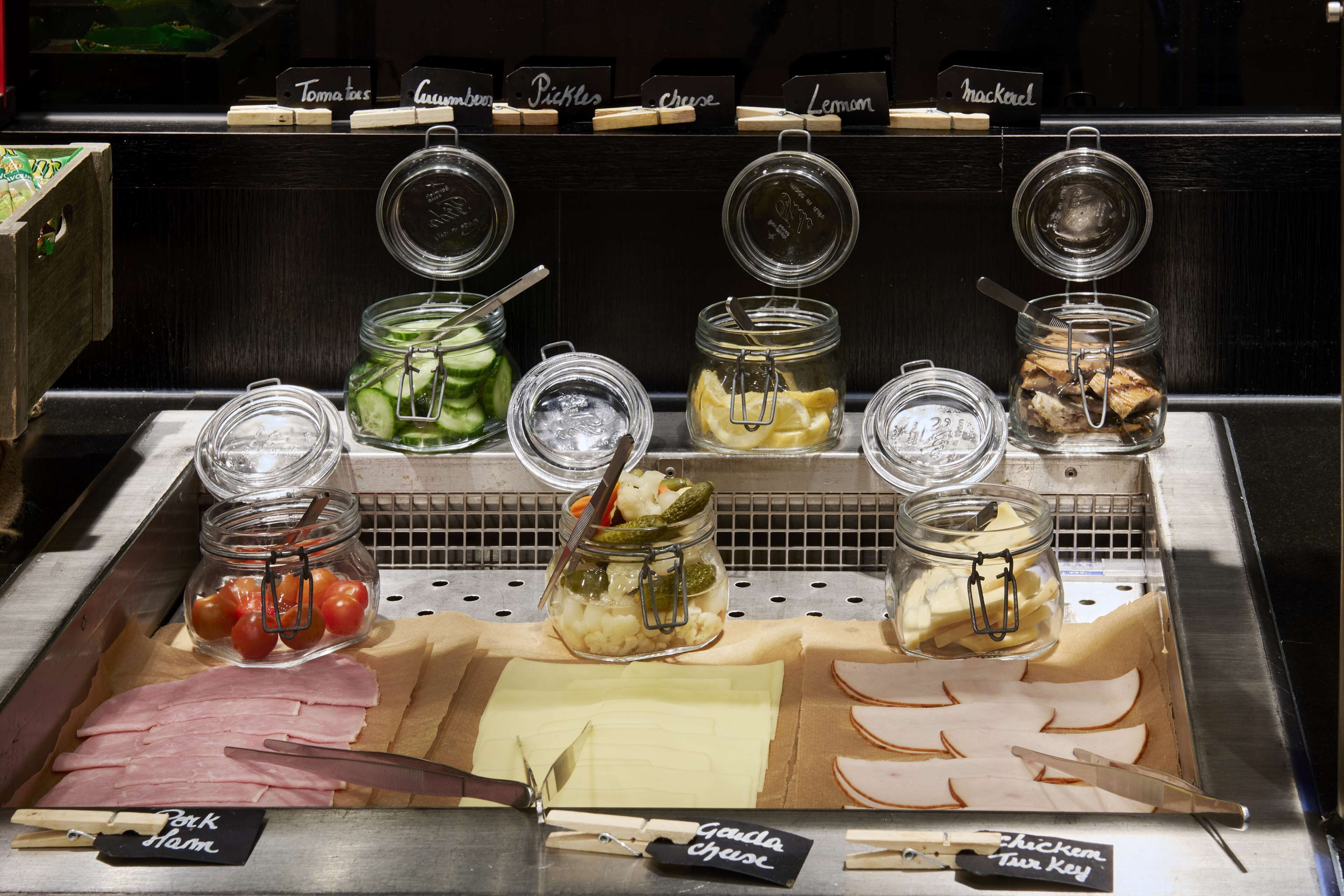 A deli counter with various food items and condiments.