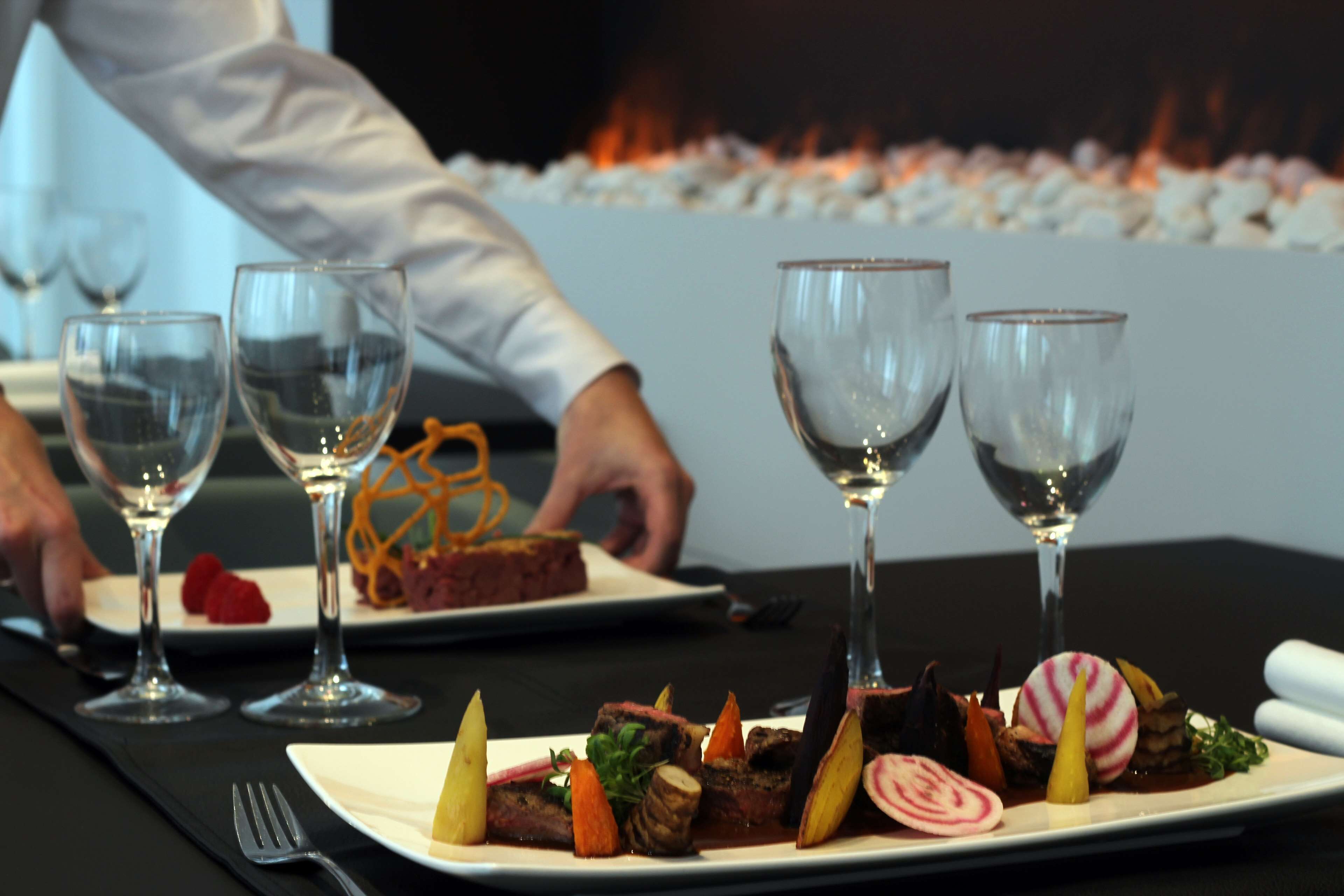 Une table à manger avec des assiettes remplies de nourriture et des verres à vin.