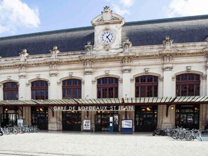 Un edificio histórico con una torre de reloj, ventanas en arco y un letrero que dice 'Gare de Bordeaux St Jean'.