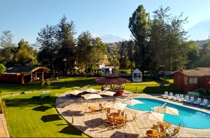 Una piscina al aire libre de temporada, sombrillas