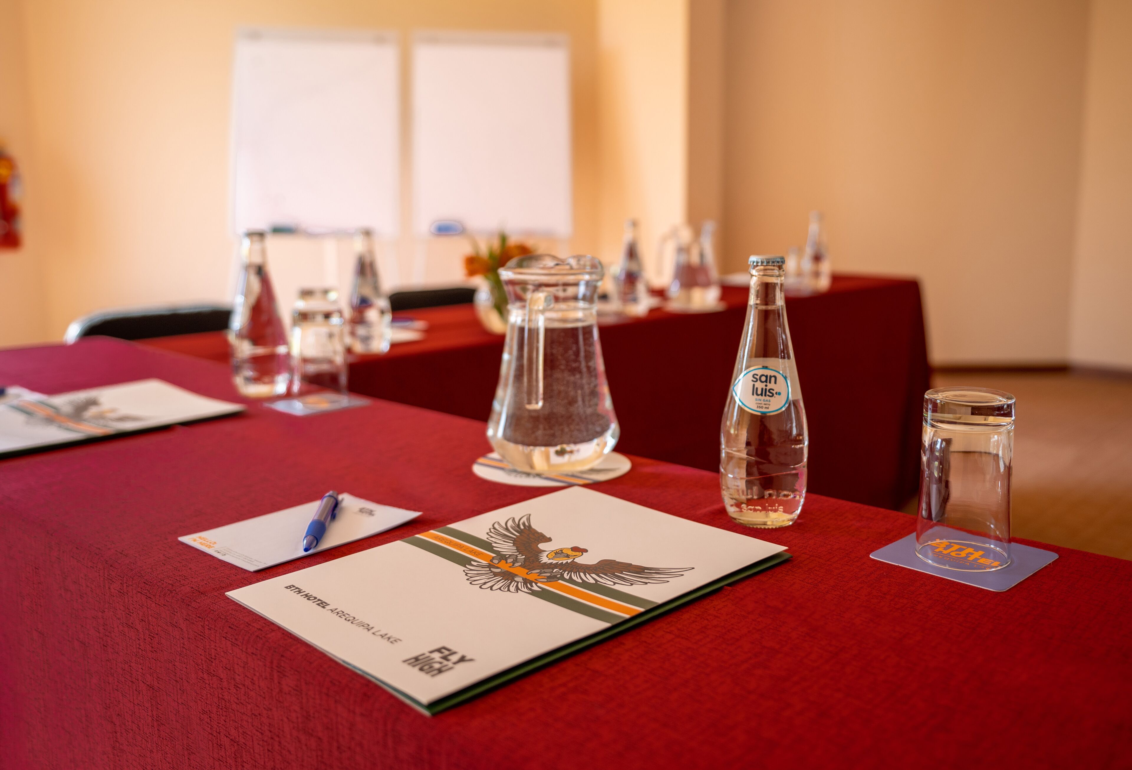 A conference table with documents, a pen, and glassware.