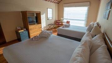 Habitación de hotel con dos camas, un televisor, un escritorio y una ventana con vistas.