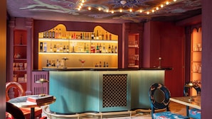 A bar area with a counter, shelves of bottles, and a decorative ceiling. - Hôtel Le Magnifique (Ex Hôtel Le M Paris)  (Paris)