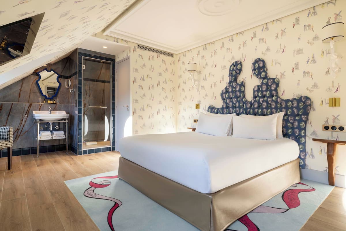 Ein modernes Schlafzimmer mit einem großen Bett, einer integrierten Dusche und einem einzigartigen Wandgemälde.