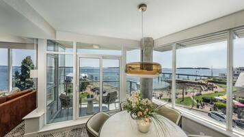A modern room with a large window, a dining table, and a hanging light fixture.