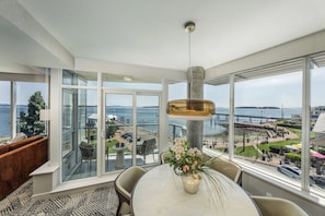 A modern room with a large window, a dining table, and a hanging light fixture. - The Sidney Pier Hotel (Sidney)