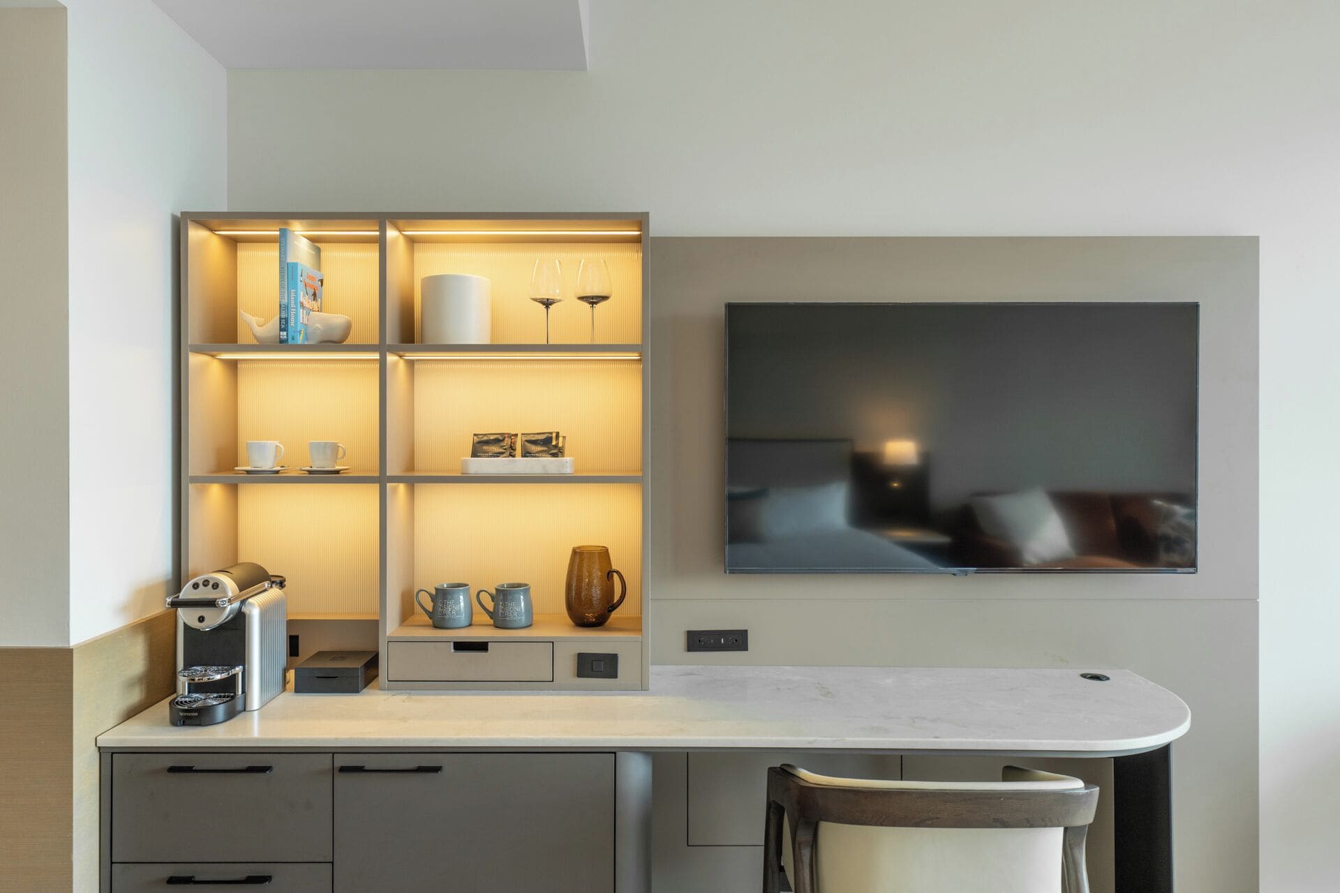 A modern kitchen with a built-in espresso machine, a coffee maker, and a coffee table.