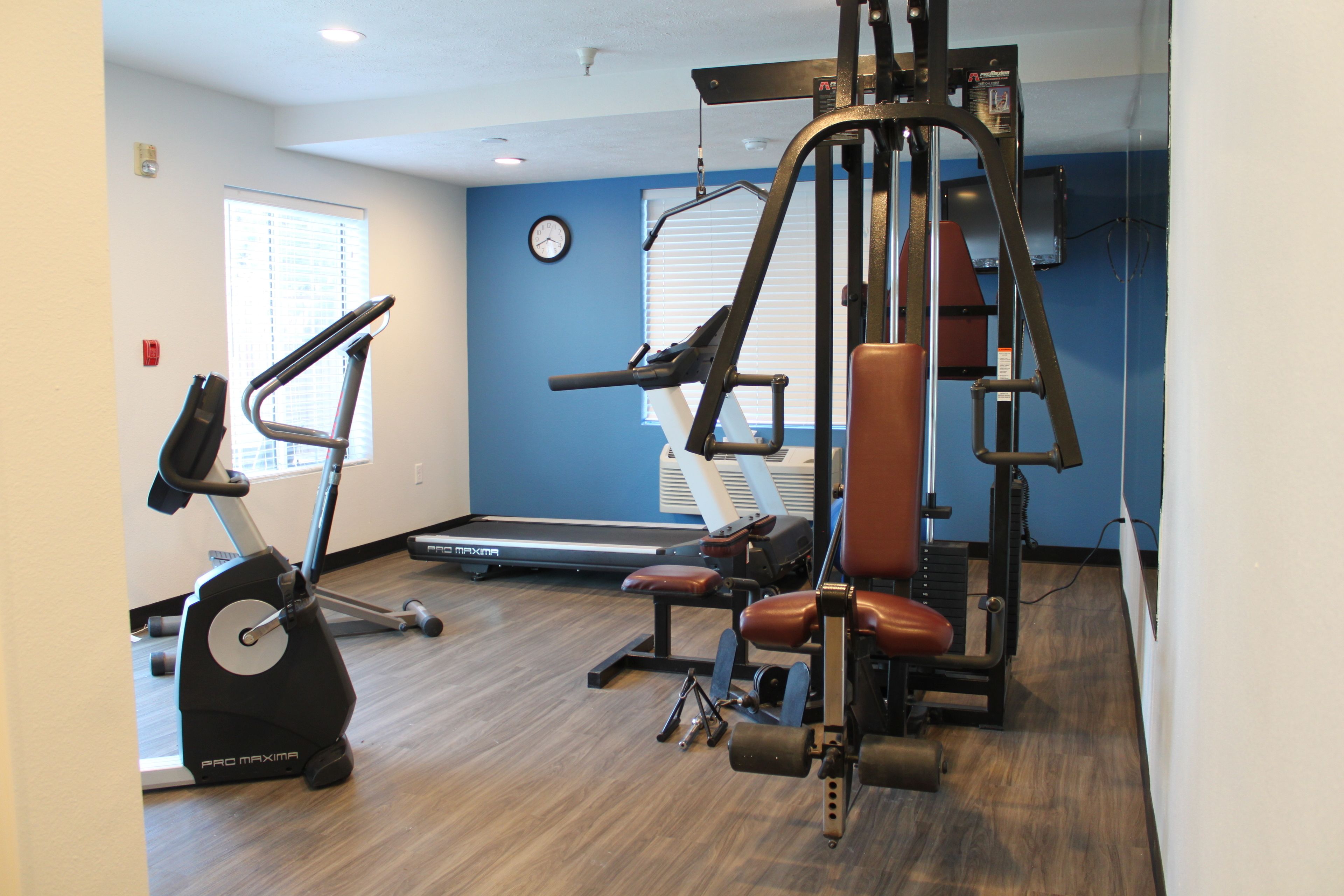 A gym with cardio equipment, weight machines, and a treadmill.