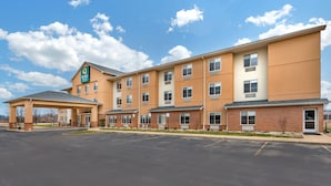 A multi-story hotel with a covered entrance and a parking lot.