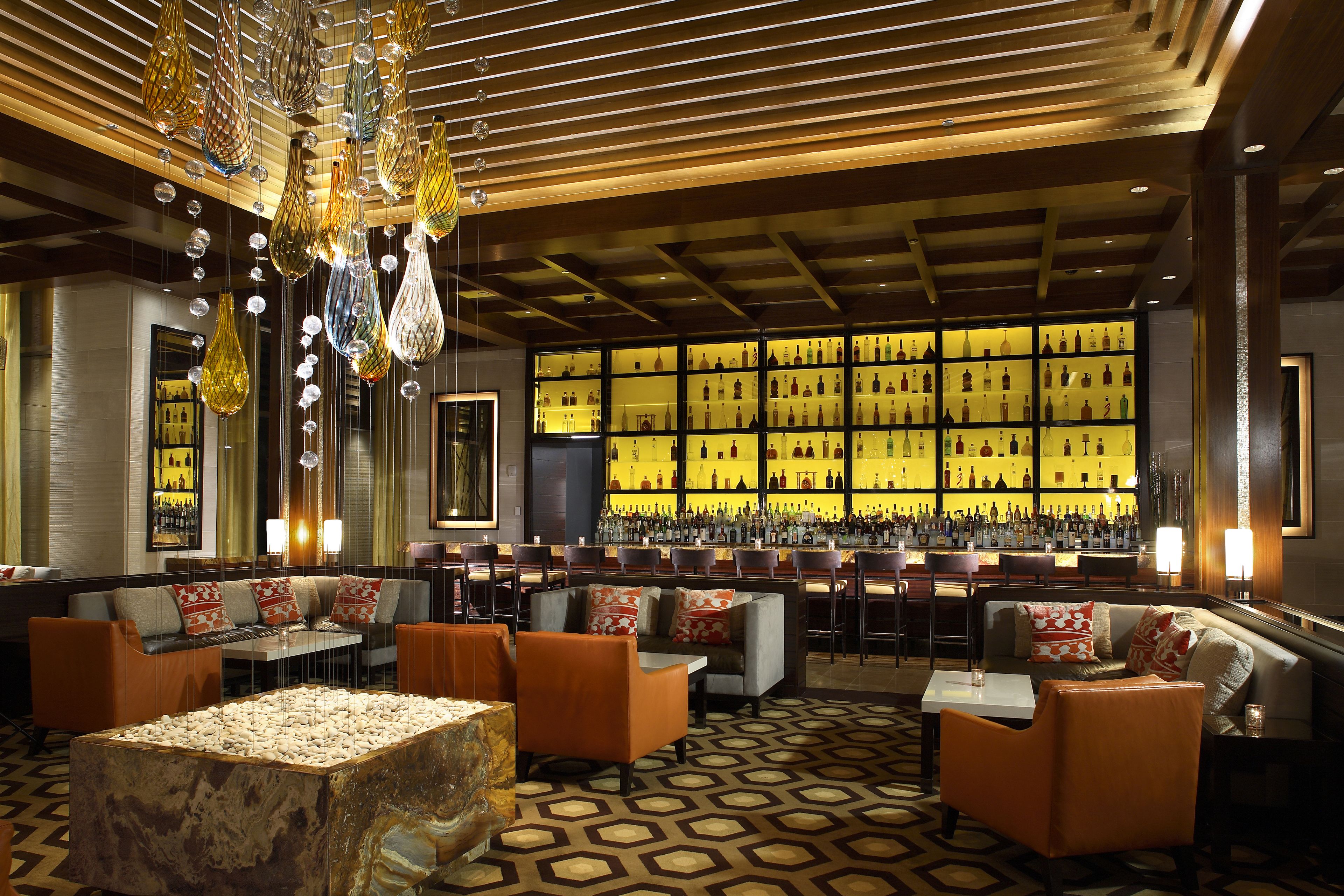A bar area with seating and a display of bottles.