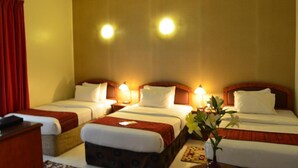 A hotel room with two beds, a desk, and a nightstand. - Nejoum Al Emarate (Sharjah)