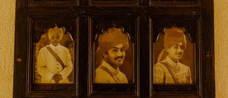 A wooden display case with six framed photographs of individuals in traditional attire.