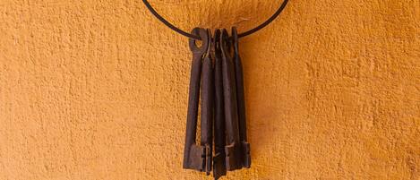 A black circular object hanging on a textured orange wall.