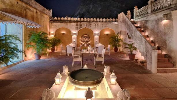 A courtyard with a dining area, a fountain, and a staircase. - Rawla Narlai (Desuri)