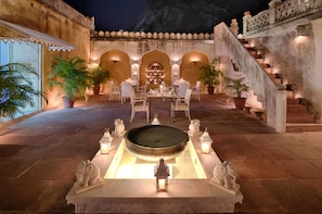 A courtyard with a dining area, a fountain, and a staircase. - Rawla Narlai (Desuri)