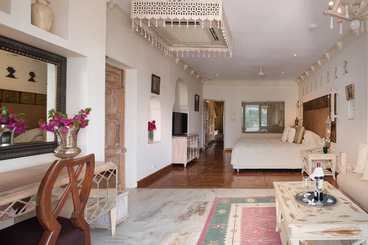 A spacious living room with a large sofa, a coffee table, and a decorative mirror.