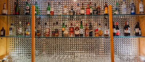 Un bar con numerosas estanterías repletas de botellas de licores.