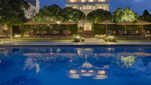 A luxurious hotel with a large pool, outdoor seating with umbrellas, and a grand building in the background. - Rawla Narlai (Desuri)