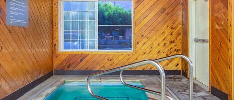 Un intérieur en bois avec une piscine, une fenêtre et une porte.