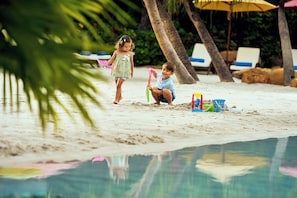 Two children playing on a sandy beach with a pool in the background. - InterContinental Shenzhen by IHG (Shenzhen)
