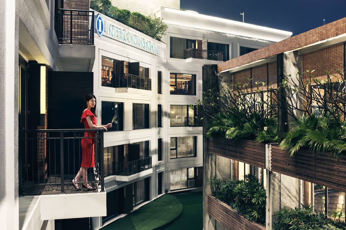 A multi-level building with balconies, a sign reading "INTERCONTINENTAL," and indoor plants.