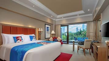 A hotel room with a large bed, a desk, a chair, a TV, and a balcony with a city view.