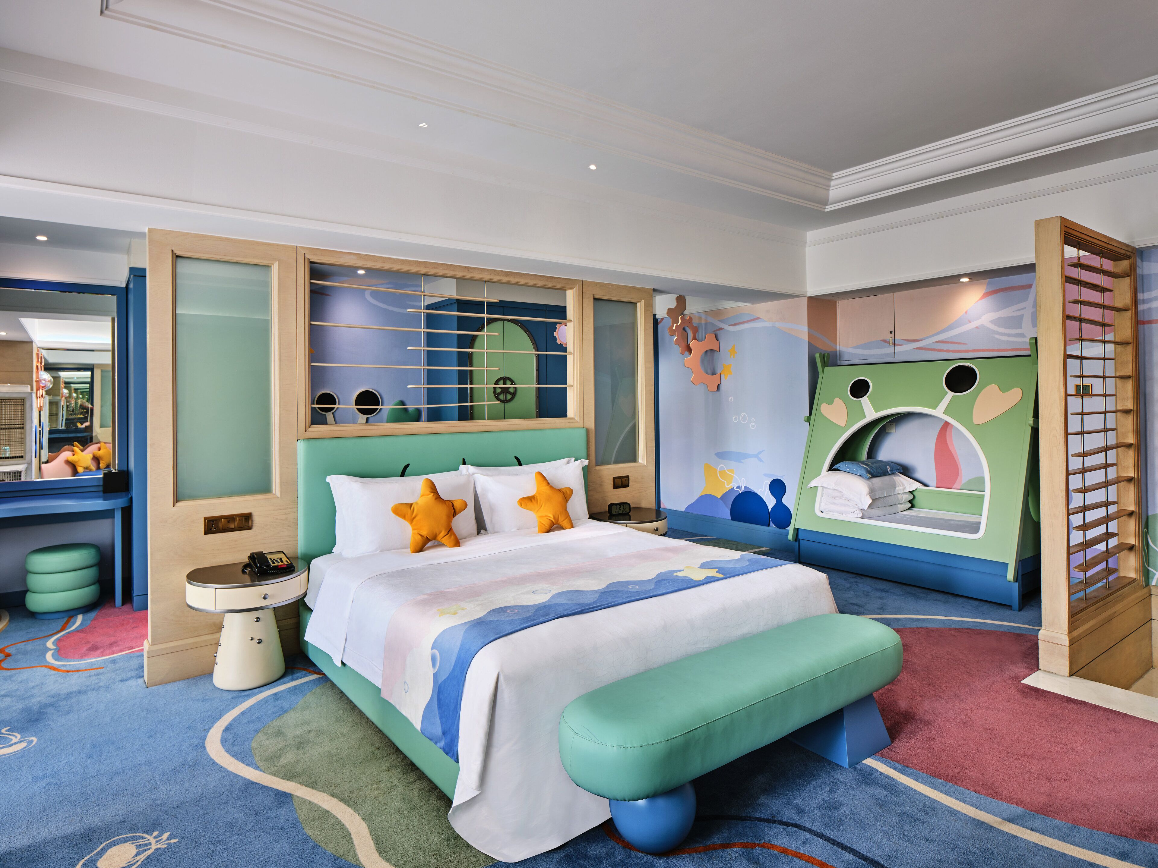 A children's bedroom with a bed, a bench, a mirror, and a wall mural.