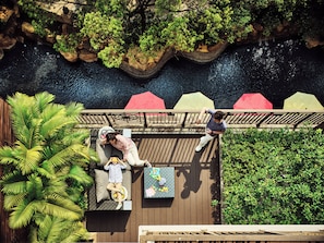 A rooftop deck with a wooden floor, a seating area with a sofa and a table, and a view of a water body. - InterContinental Shenzhen by IHG (Shenzhen)