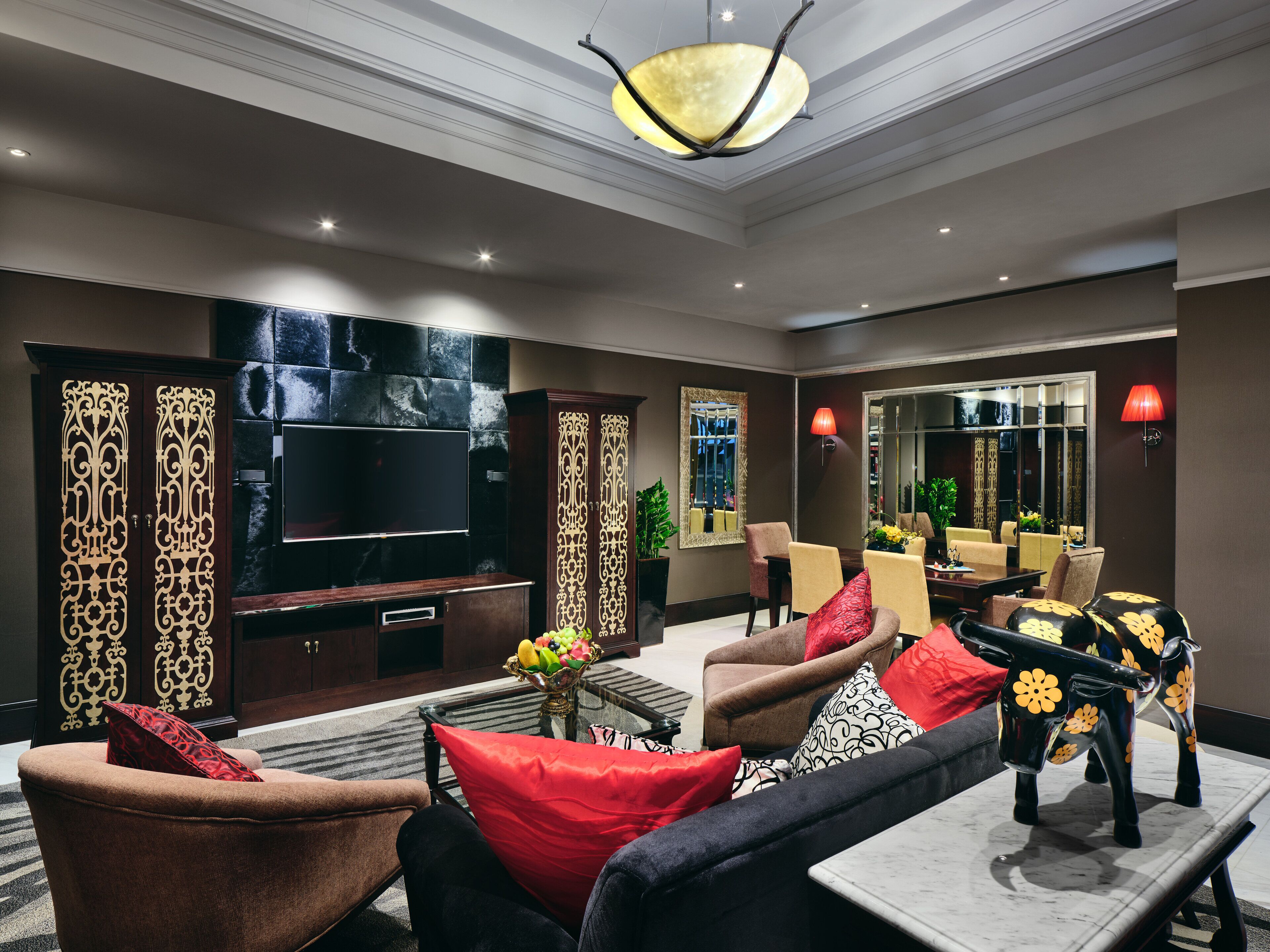 A modern living room with a flat-screen TV, comfortable seating, and decorative elements.