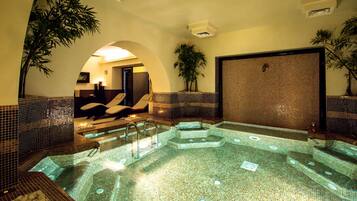Relax in a serene spa area with a hot tub and lush greenery.