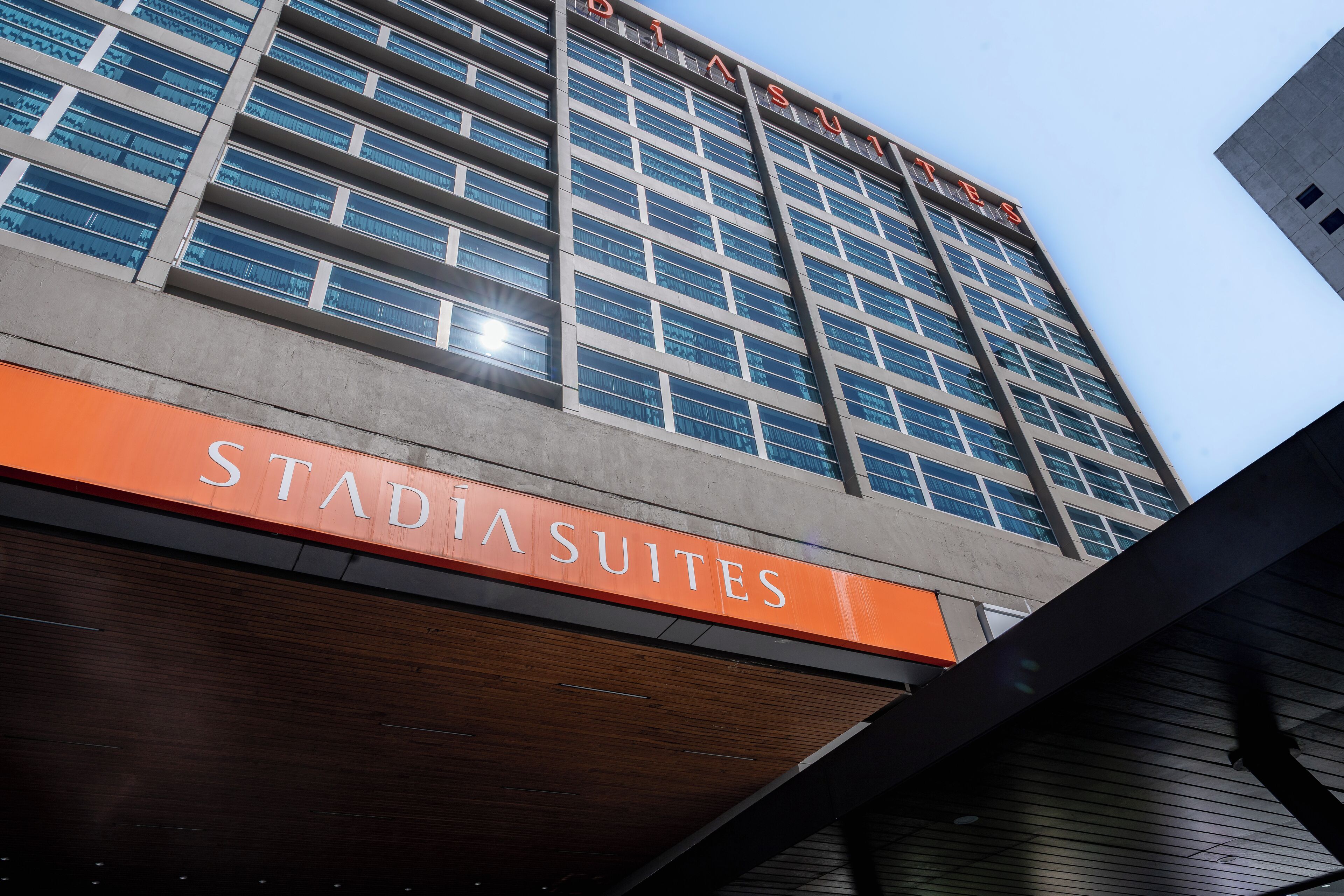 A hotel building with a sign for 'Stadiasuites'.