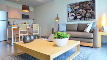 Uma sala moderna com sofá, mesa de centro e área de jantar com cadeiras e mesa.