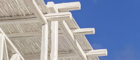 A white building with a sloped roof and a clear blue sky in the background.
