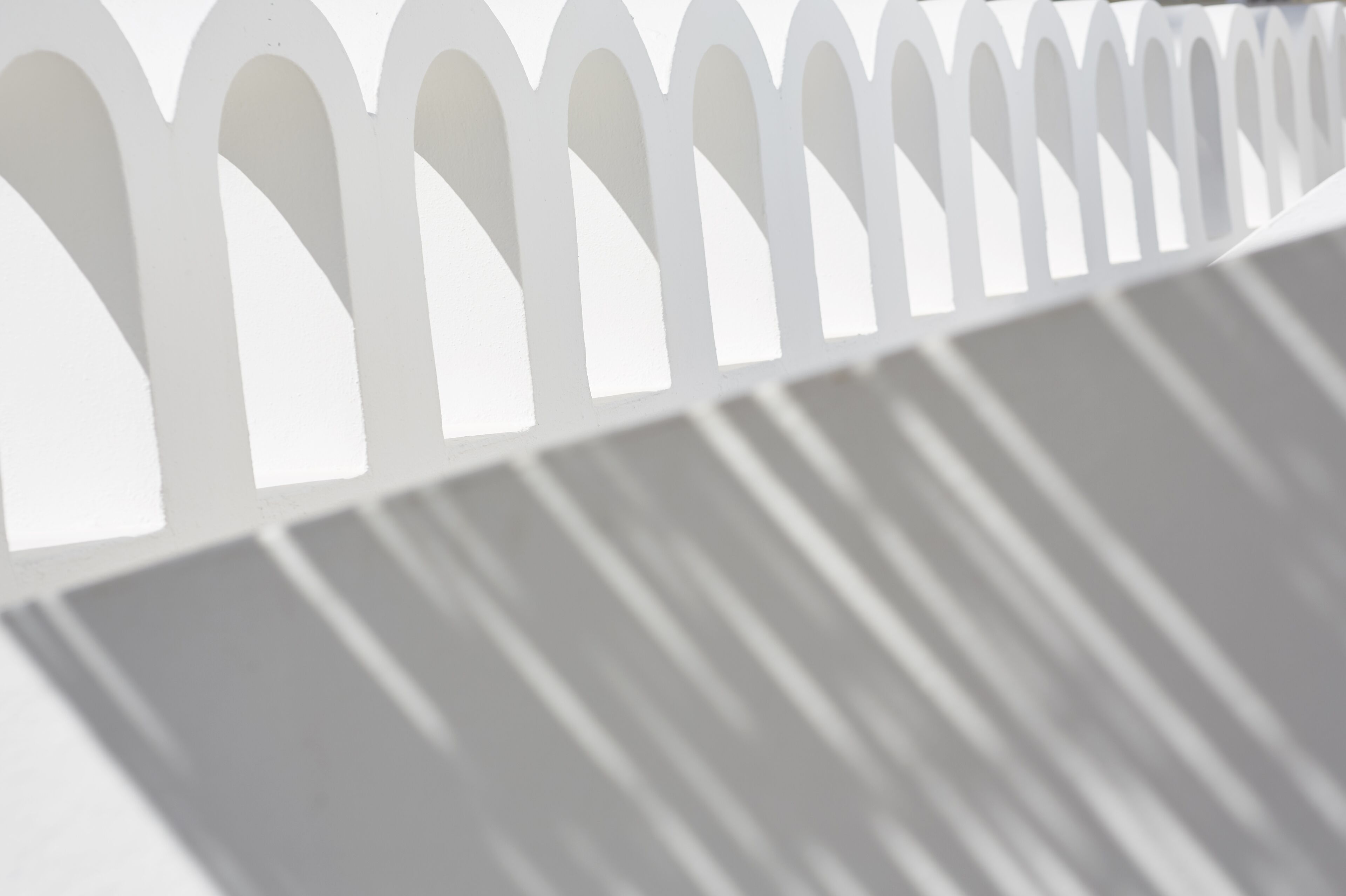 A white, geometric fence with a series of pointed arches.