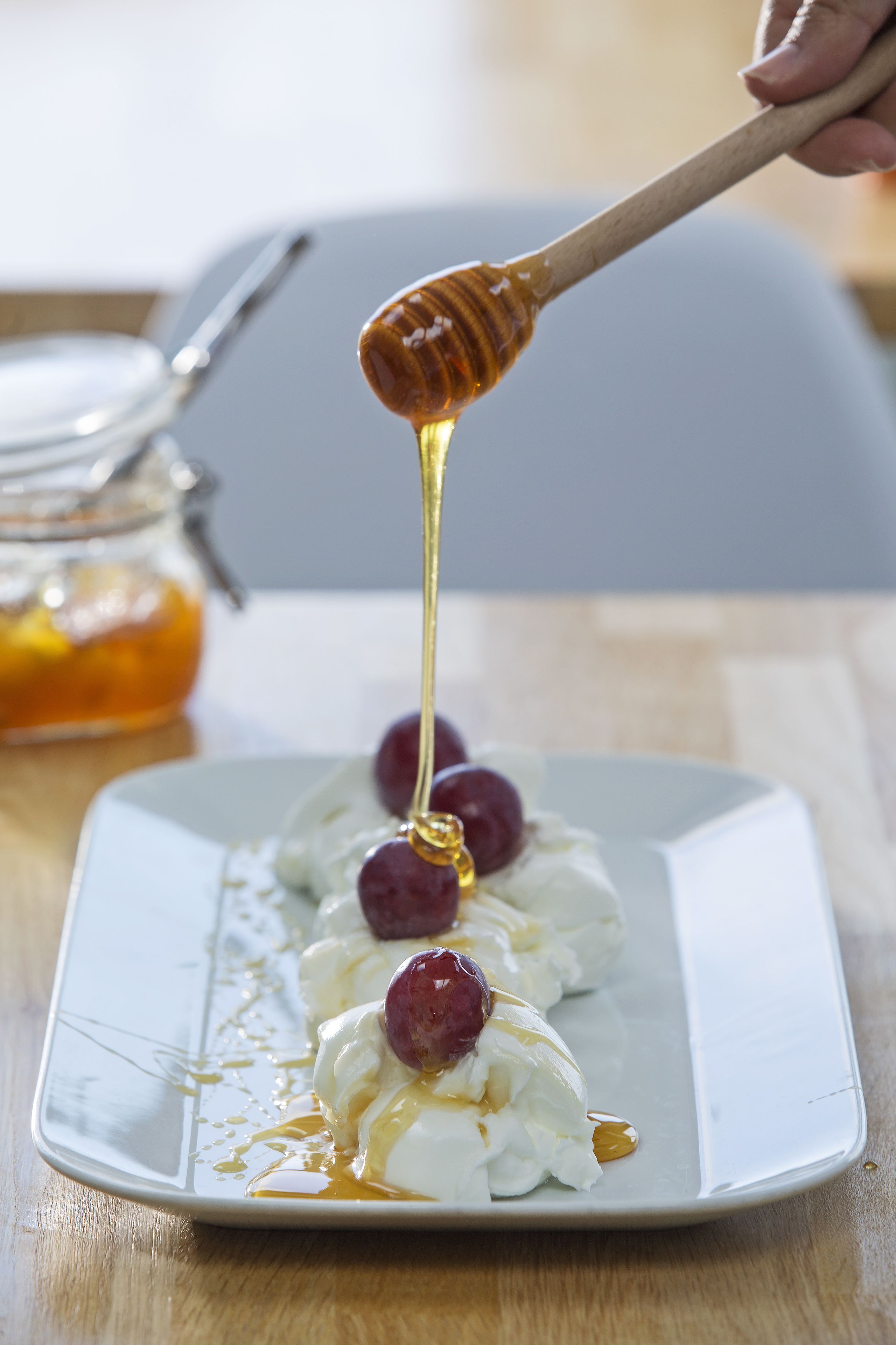 A dessert plate with whipped cream and cherries, drizzled with honey.