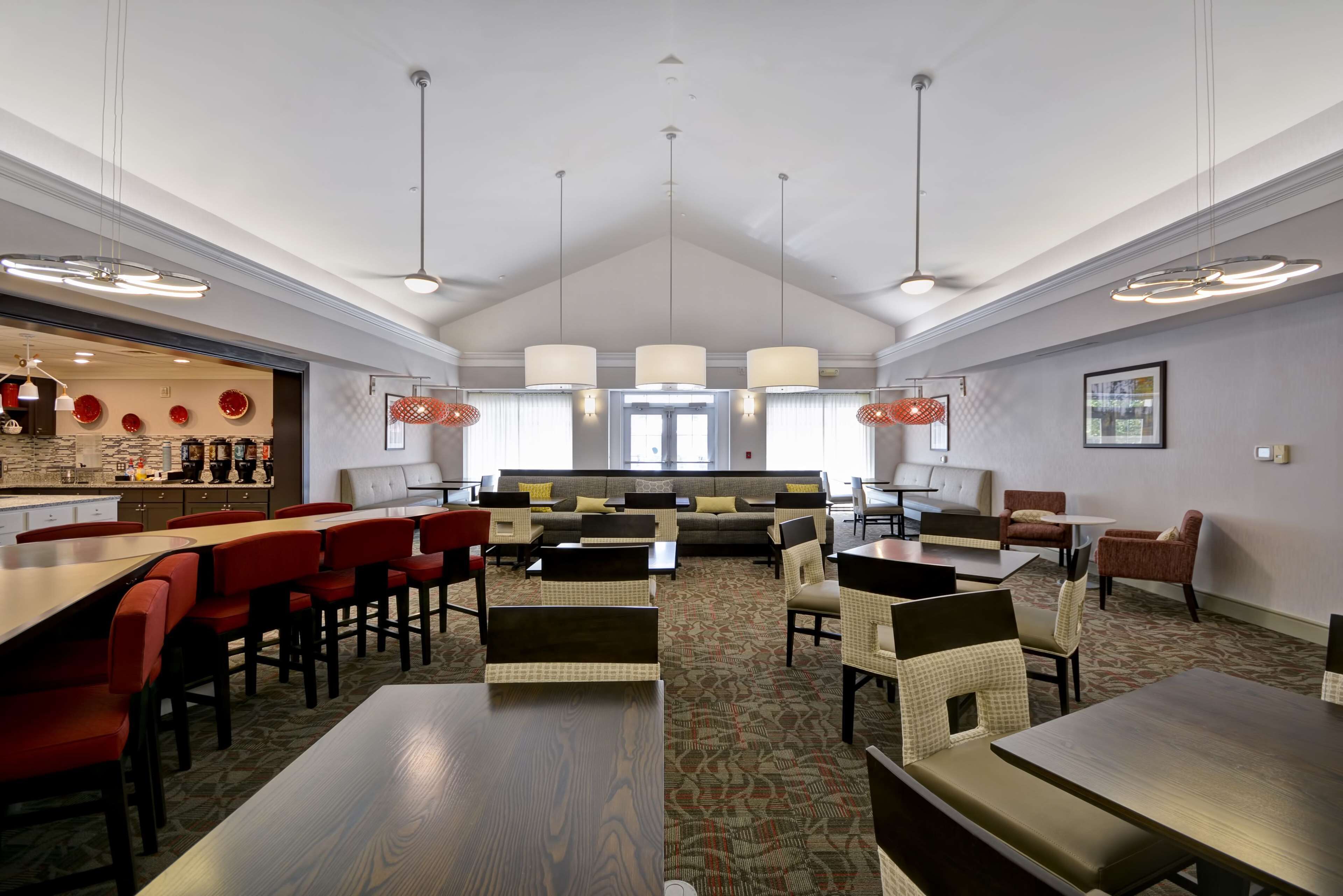 A modern hotel lobby with a bar, seating area, and a patterned carpet.