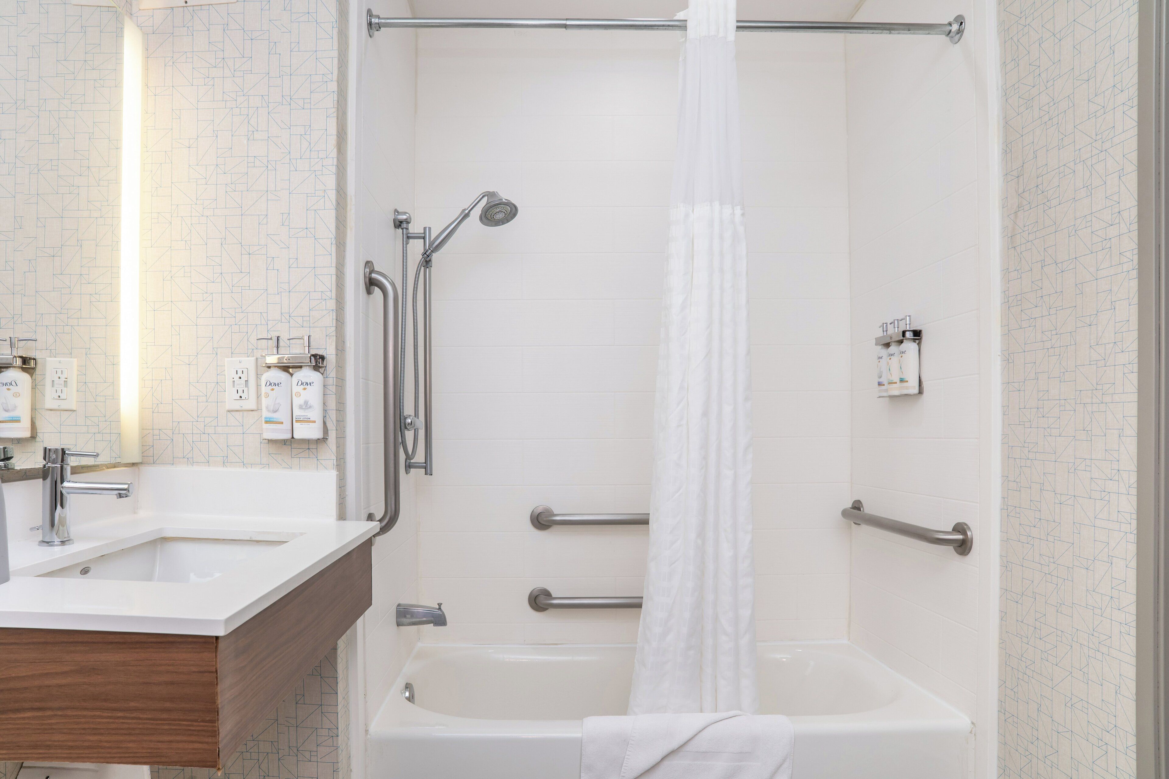 Une salle de bain moderne avec un lavabo, un miroir et un espace douche.
