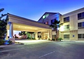 A Holiday Inn Express & Suites building with a covered entrance, palm trees, and a clear sky. - Holiday Inn Express Hotel & Suites San Diego Otay Mesa by IHG (San Diego)