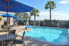A swimming pool with a surrounding deck, lounge chairs, and umbrellas. - Holiday Inn Express Hotel & Suites San Diego Otay Mesa by IHG (San Diego)