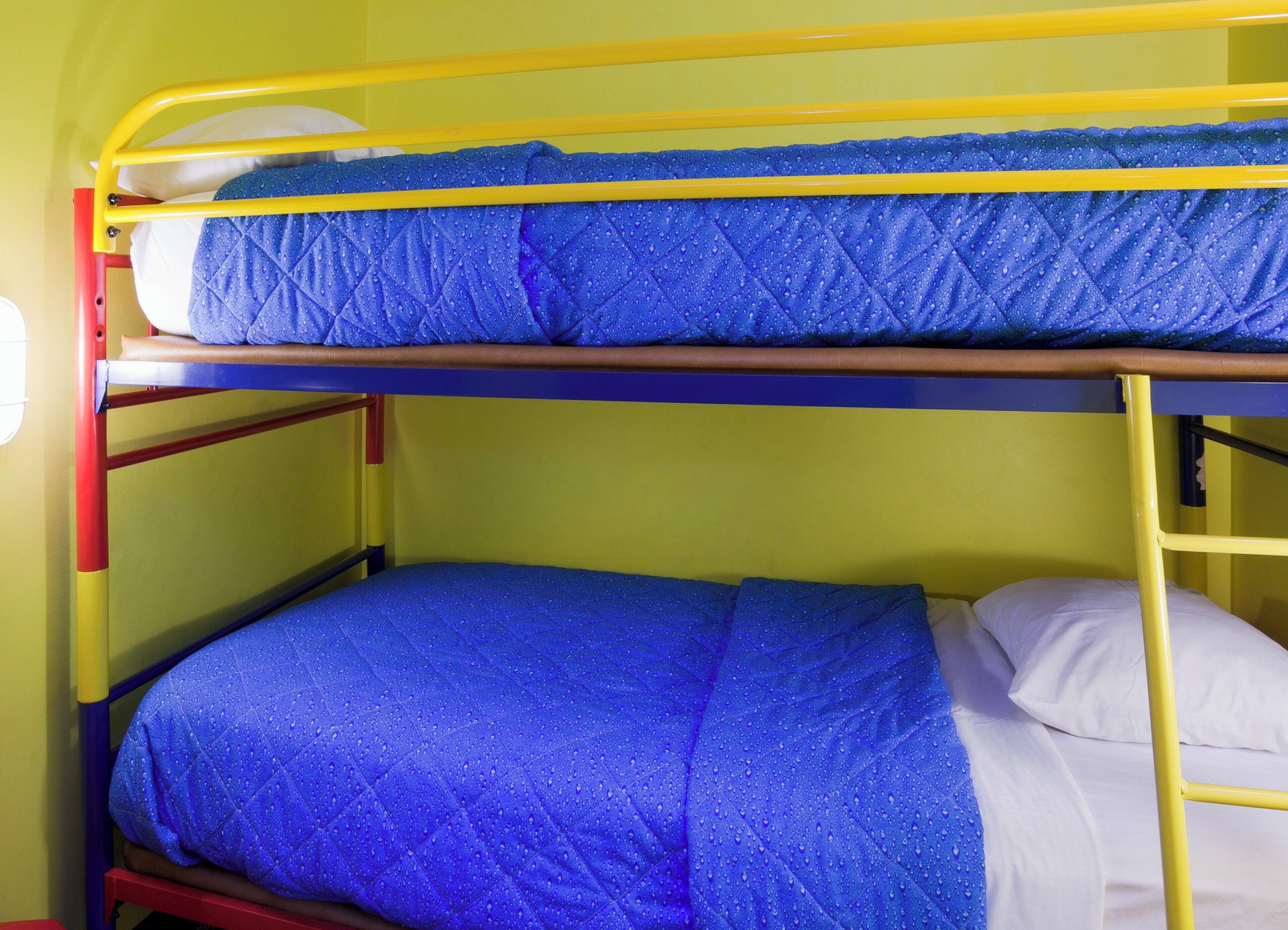 Una cama litera con ropa de cama azul y estructura amarilla.