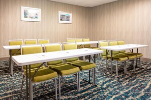 A conference room with tables and chairs, a patterned carpet, and two framed pictures on the wall. - Hampton Inn Freeport (Freeport)