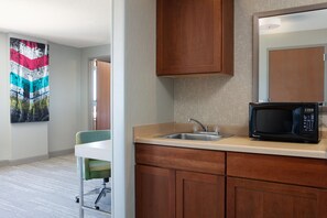 A modern kitchen with a microwave, sink, and wooden cabinets. - Hampton Inn Freeport (Freeport)
