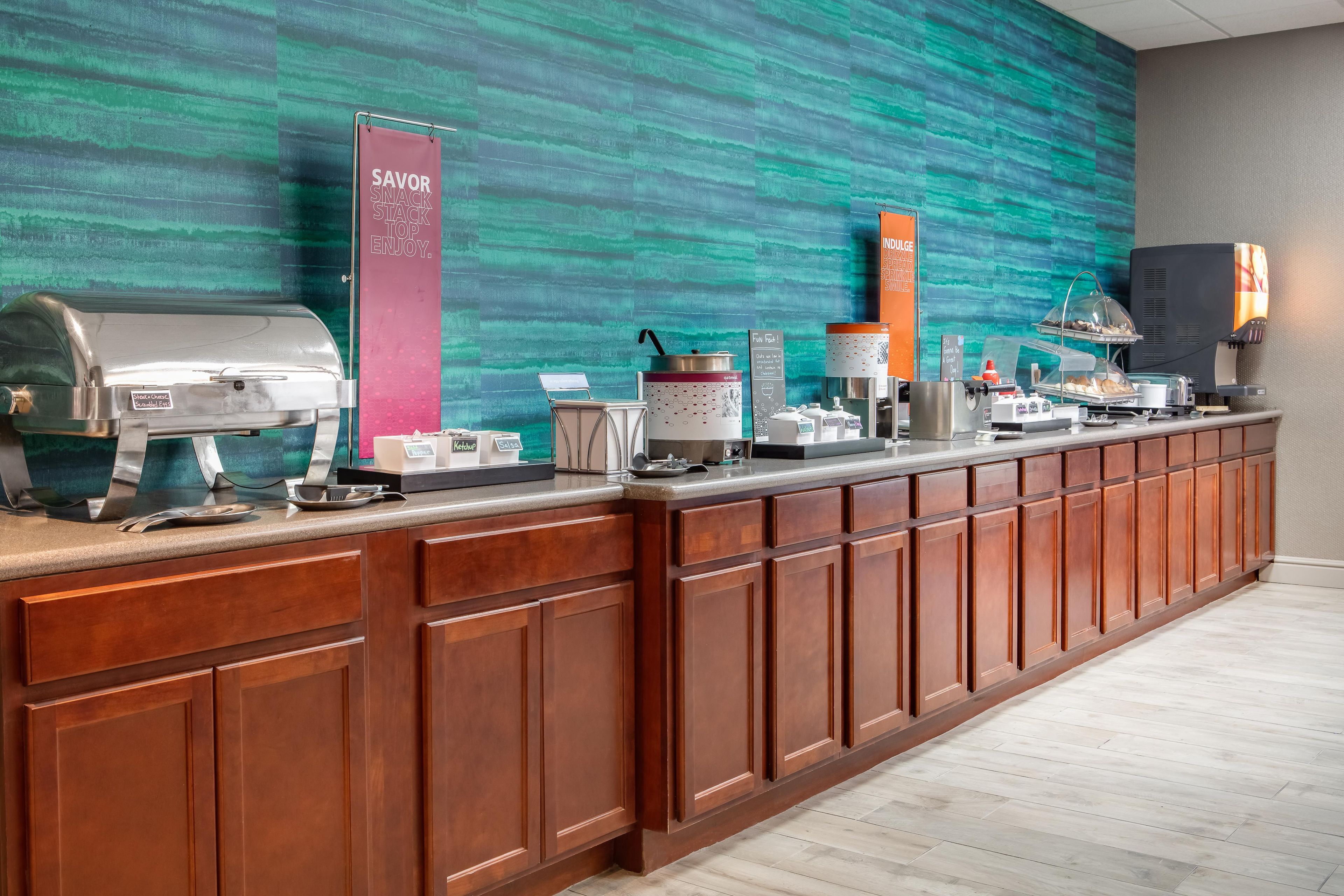A buffet counter with various food options and a coffee station.