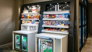A snack display with various packaged foods and a refrigerated section with beverages.