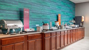 A buffet counter with a variety of food items and a coffee machine.