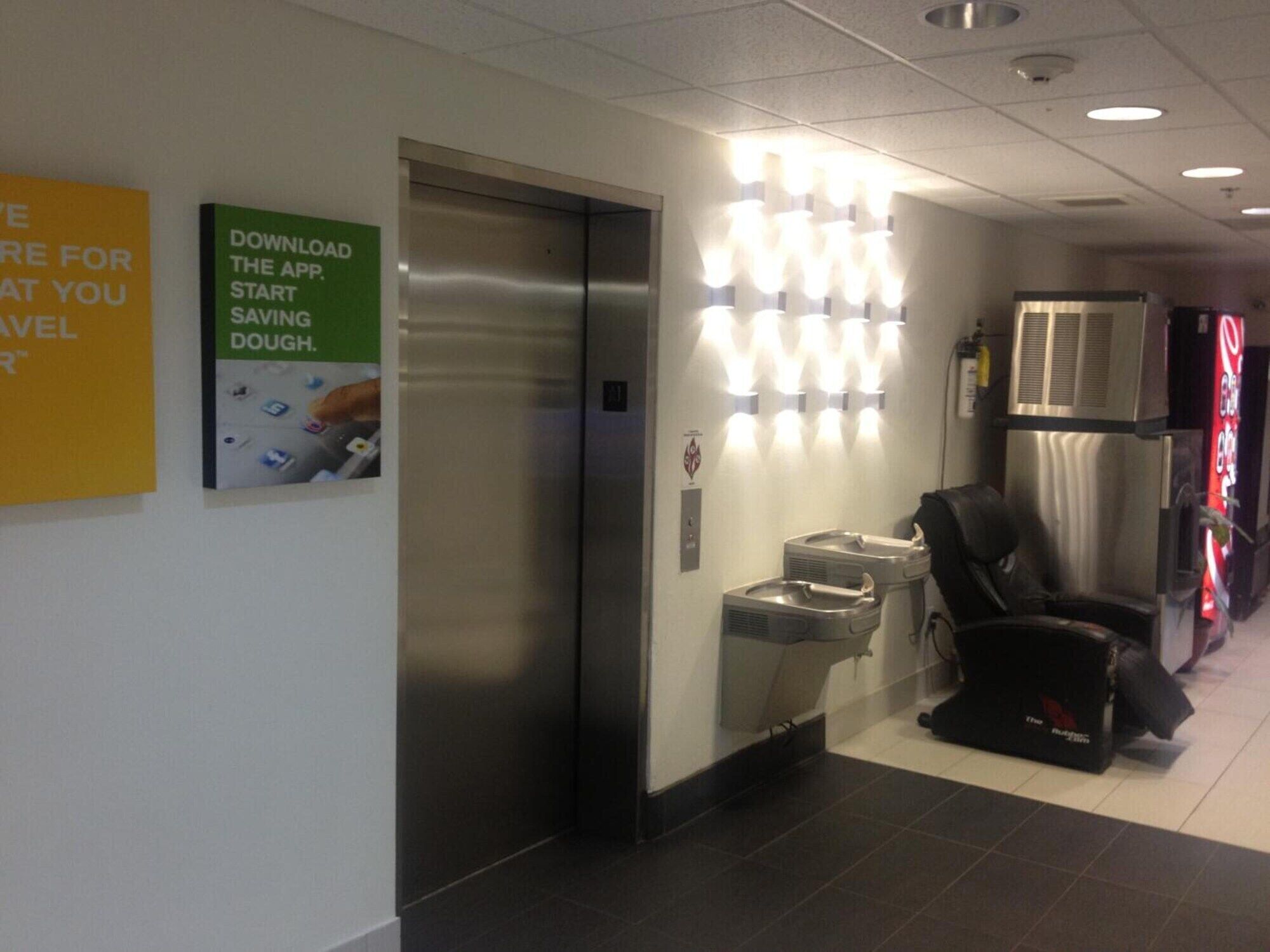 An elevator with a sign instructing to download an app for saving dough.