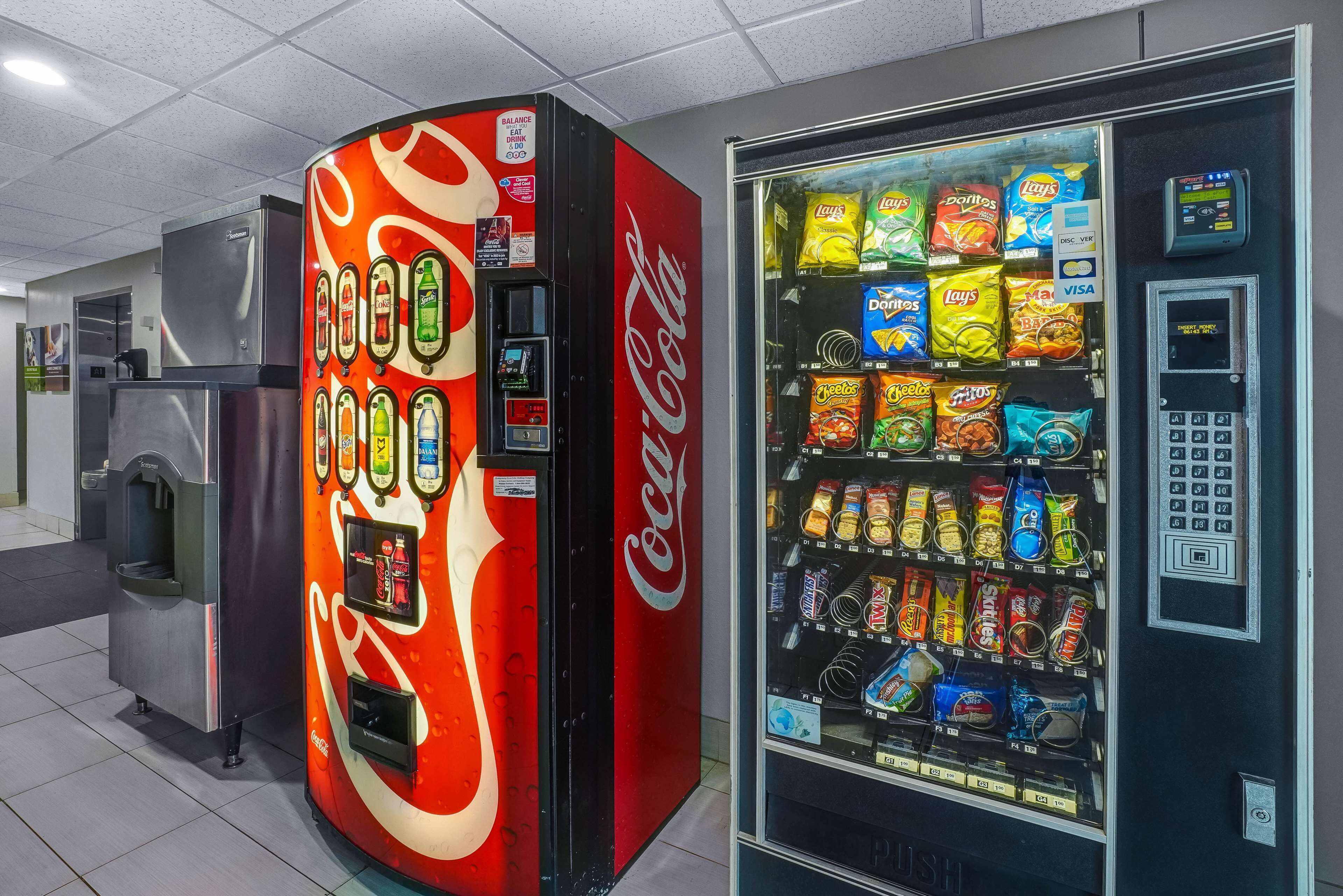 Un distributeur automatique aux couleurs de Coca-Cola et un autre distributeur proposant une variété de collations.