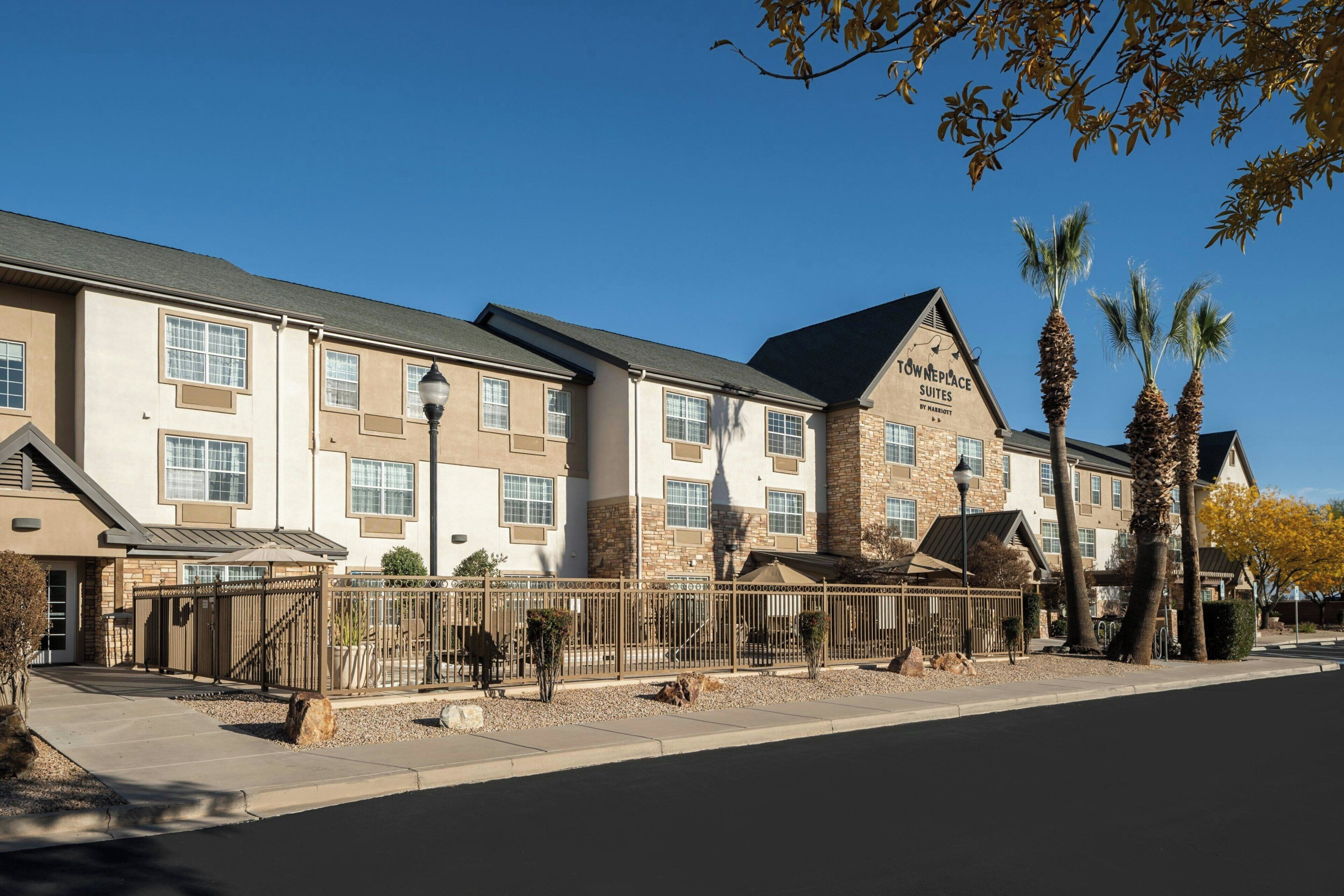 A hotel with a stone facade, multiple windows, and a sign indicating 'TOWNEPLACE SUITES.'